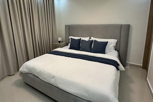 Spacious primary bedroom with a king bed, A/C, ceiling fan, TV, and vanity/workspace. 🛏️✨