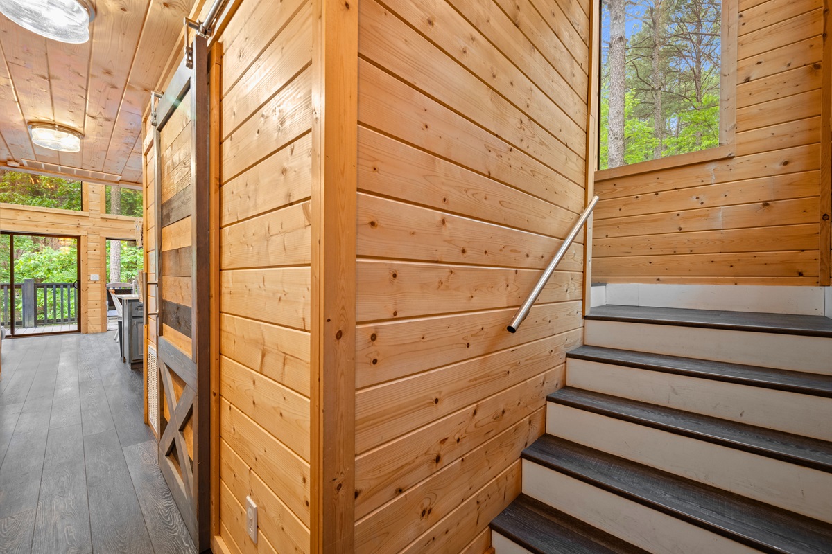 The hallway and staircase carry that same warm wood design throughout, tying the entire home together.