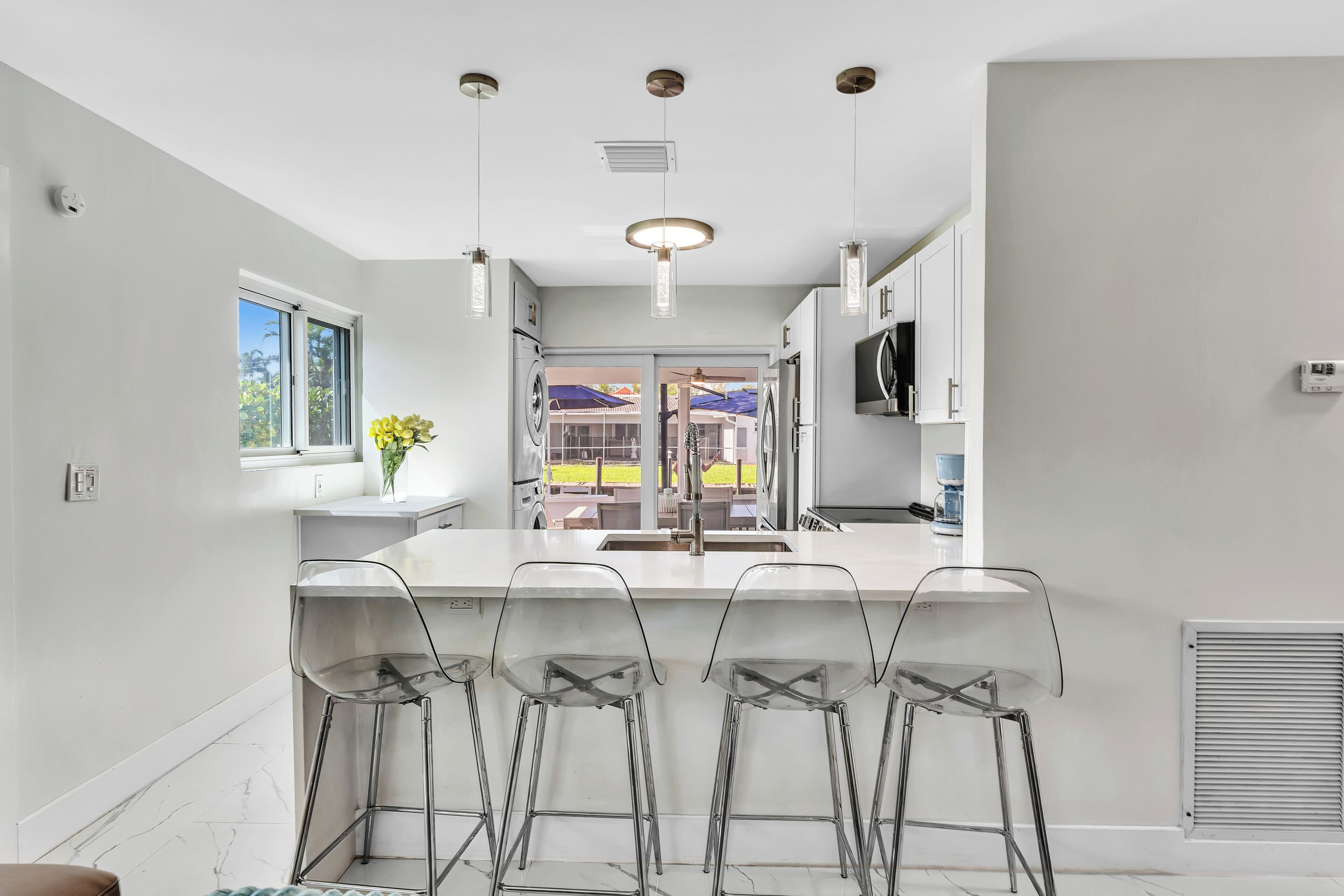 Open-concept kitchen with a large breakfast bar, seating for four, and full-size appliances.