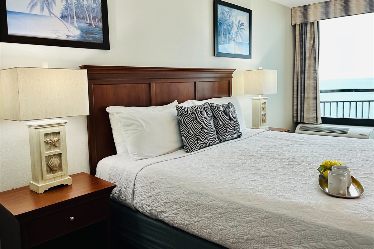 Drift into tranquility on a bed near the balcony of our oceanfront suite, where the gentle ocean breeze and stunning vistas create a peaceful haven.