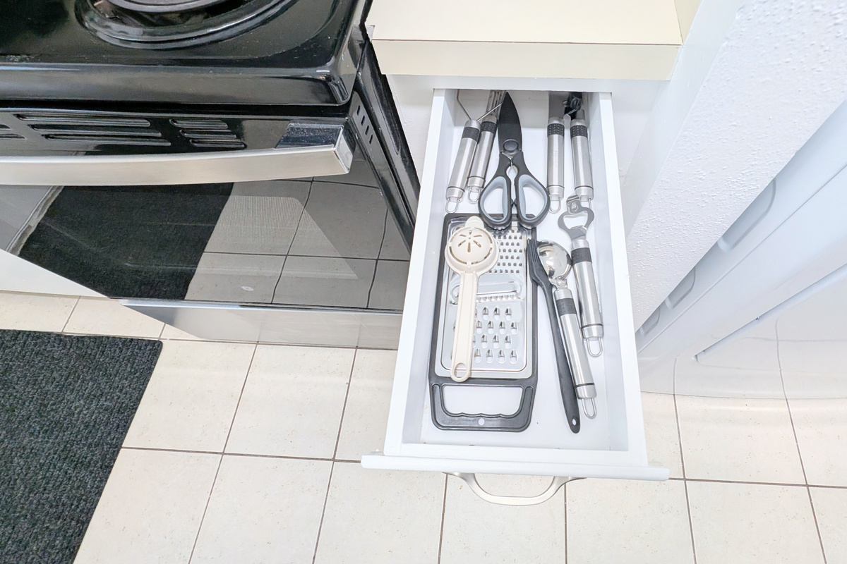 Cooking utensils, along with bottle and can openers, are kept within easy reach for simple meal prep and dining.