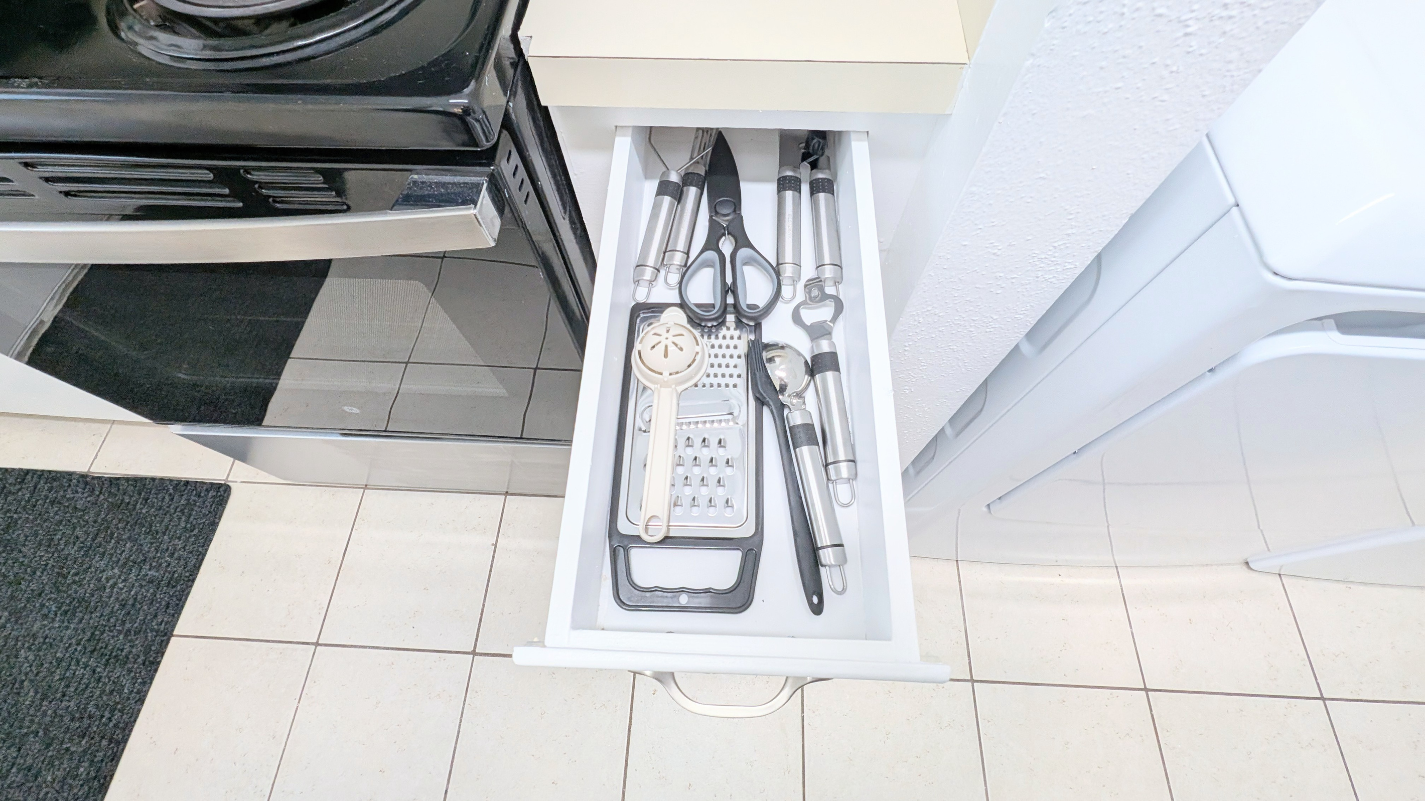 Cooking utensils, along with bottle and can openers, are kept within easy reach for simple meal prep and dining.