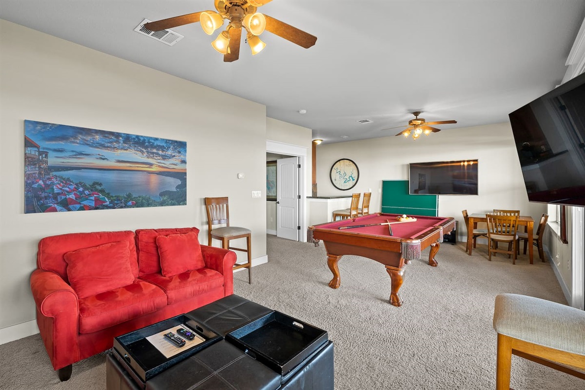 Two HDTVs, Game Table, and Multiple Seating Areas in Gameroom