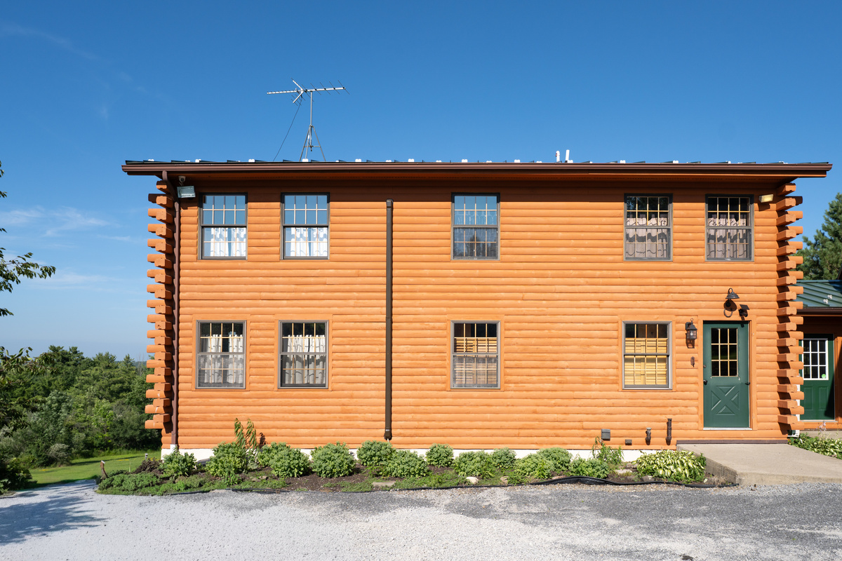 Two-story log exterior with green door