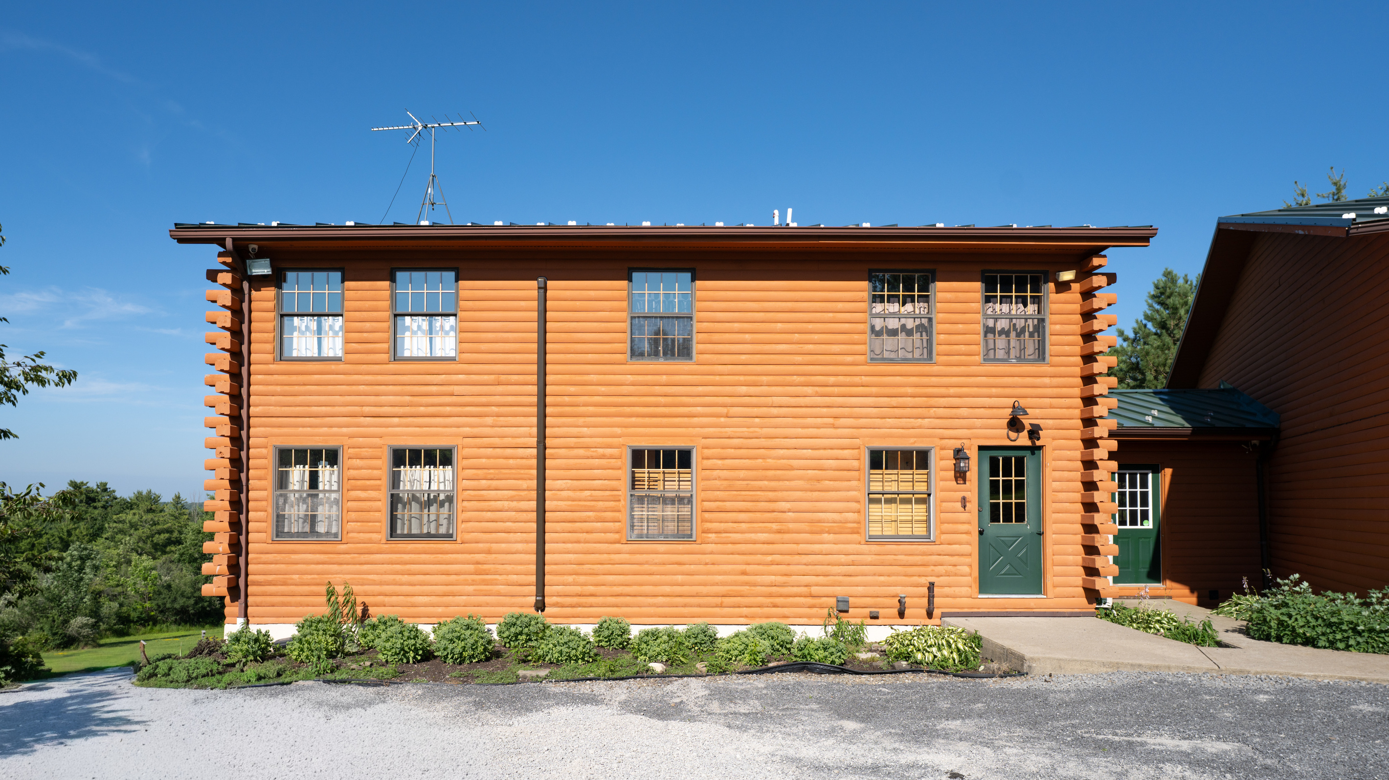 Two-story log exterior with green door
