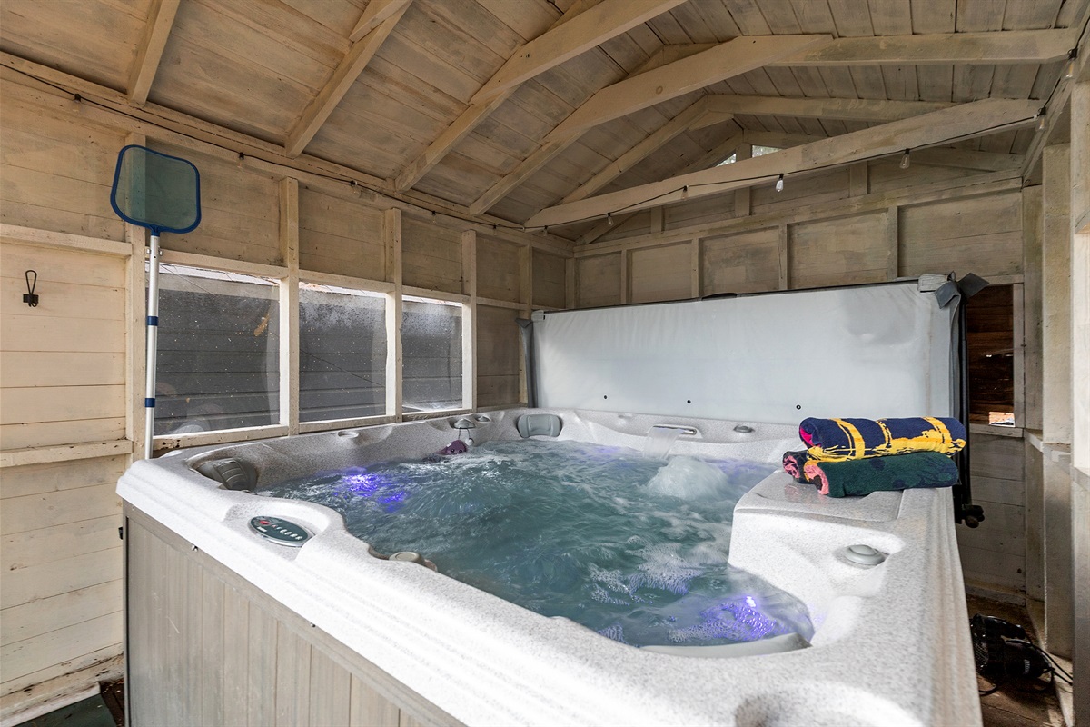 Soak in the hot tub tucked inside its own private enclosure—perfectly covered for year-round relaxation, rain or shine.