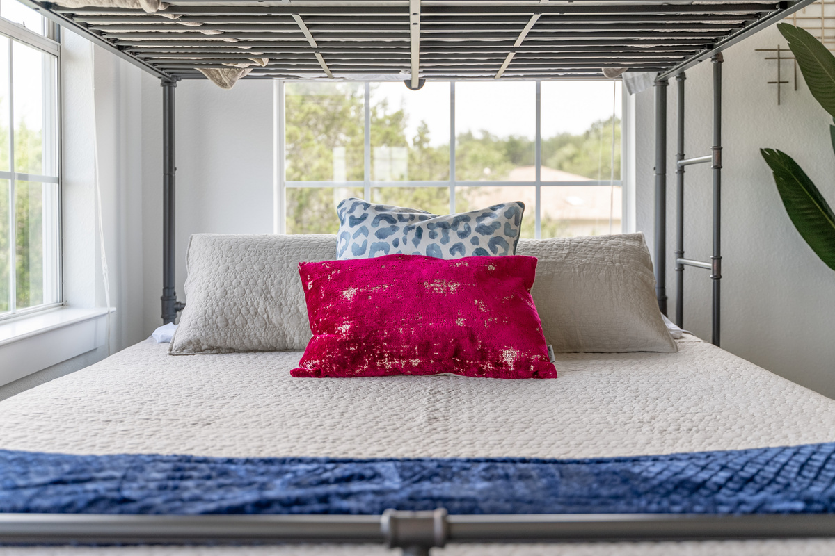Crisp white linens paired with a bold red accent pillow.