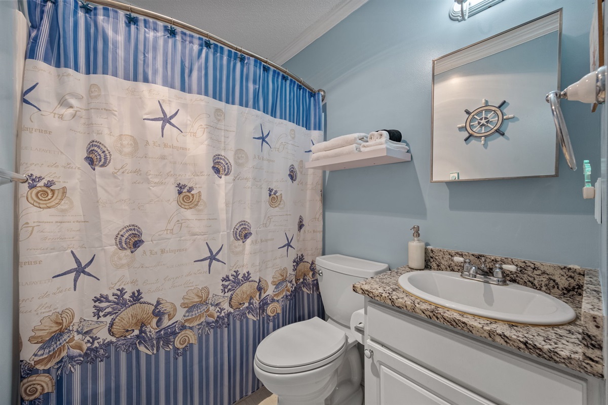Full bathroom with coastal d&eacute;cor, shower-tub combo, and fresh towels ready for your stay