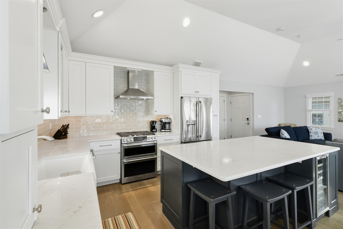 Fully-equipped kitchen with custom cabinetry, stainless appliances, and a 3-seat island for casual dining