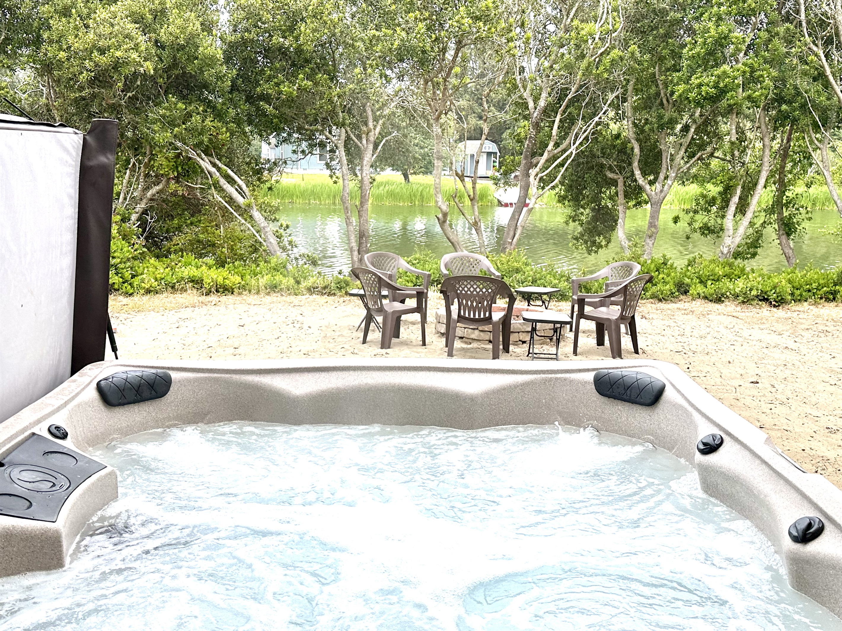 Slide into the hot tub as the jets kick on and the canal goes still and green in front of you — four chairs waiting for the rest of your crew to join.