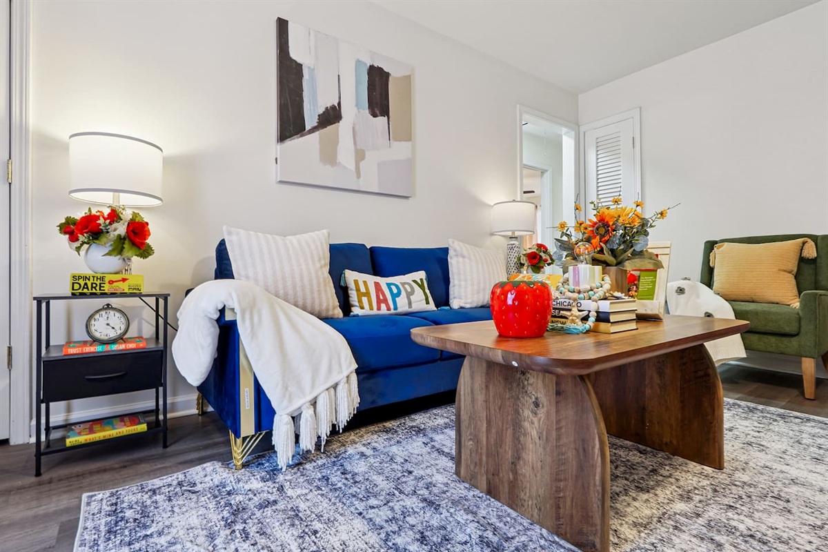 The living room features cozy furniture, including a comfortable blue couch, and an Amazon Fire-powered Smart TV for your entertainment. You’ll also find the Xfinity modem conveniently located here, convenient for ethernet connection.