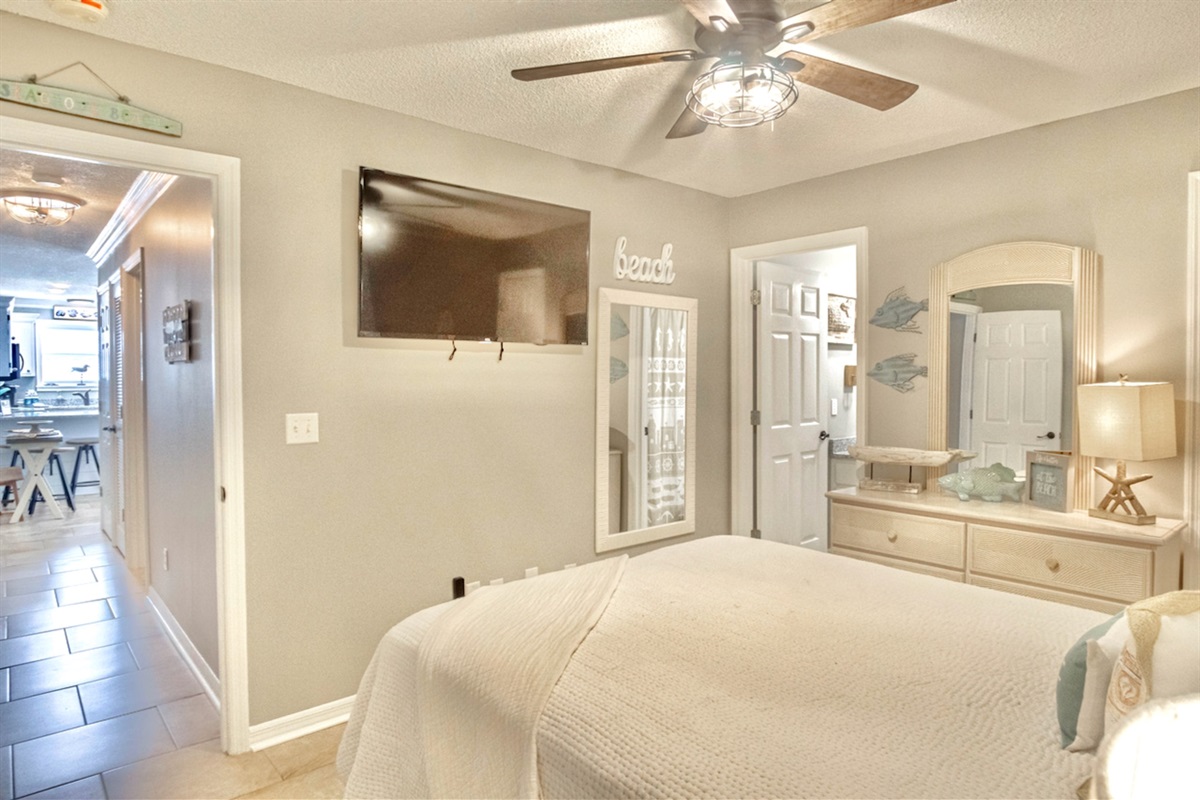 Master bedroom with queen bed, smart TV, ceiling fan, and ensuite bathroom