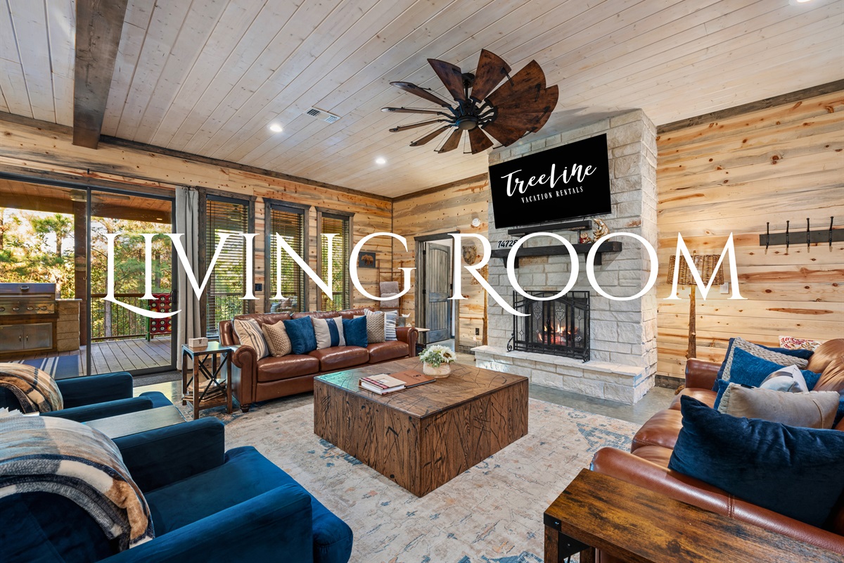 The living room invites you to kick back and relax with cozy seating and beautiful views of the surrounding forest.