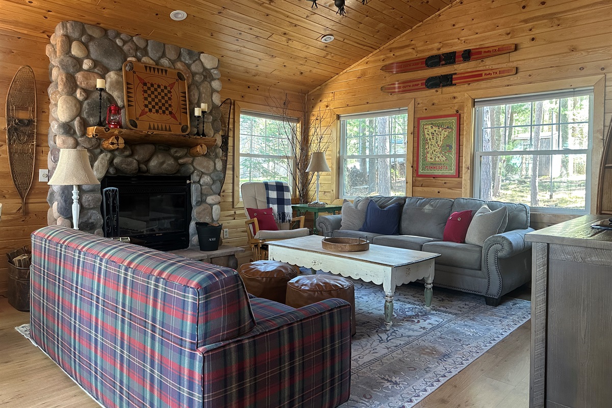 Rustic pine interiors, vaulted ceiling, a warm wood-burning fireplace, and Roku Smart TV, perfect for games, books, movie watching, and relaxing evenings.