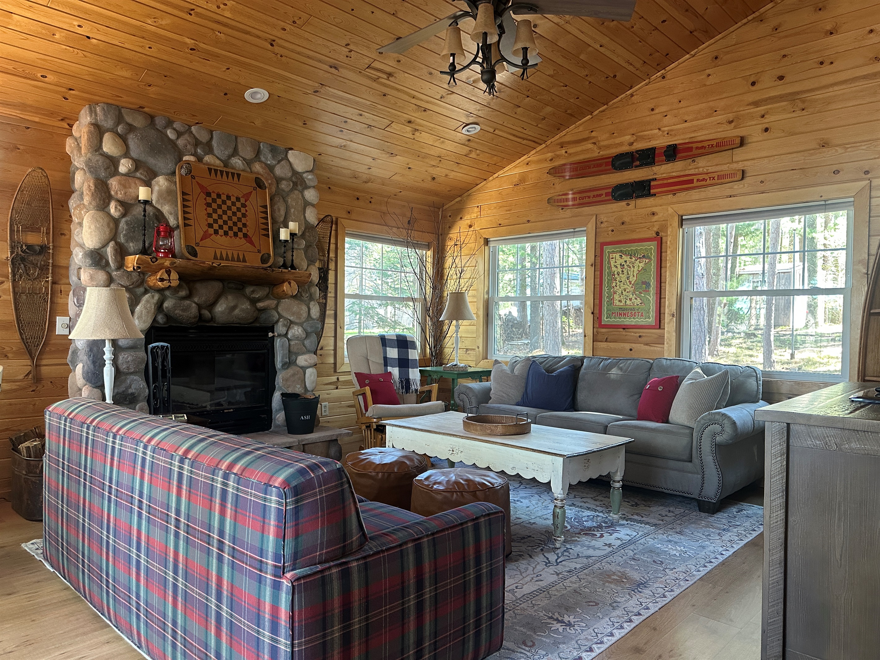Rustic pine interiors, vaulted ceiling, a warm wood-burning fireplace, and Roku Smart TV, perfect for games, books, movie watching, and relaxing evenings.