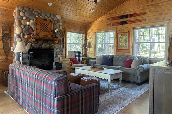 Rustic pine interiors, vaulted ceiling, a warm wood-burning fireplace, and Roku Smart TV, perfect for games, books, movie watching, and relaxing evenings.