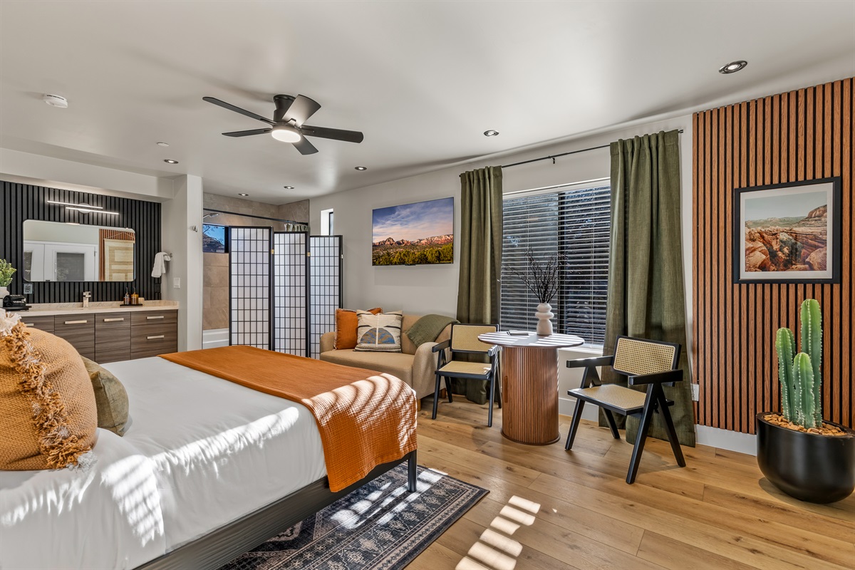 An open-concept guesthouse suite featuring a king bed, lounge seating, and thoughtful desert-inspired design.