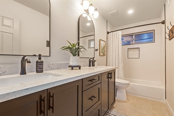 Upstairs guest bathroom with dual sinks and full tub/shower