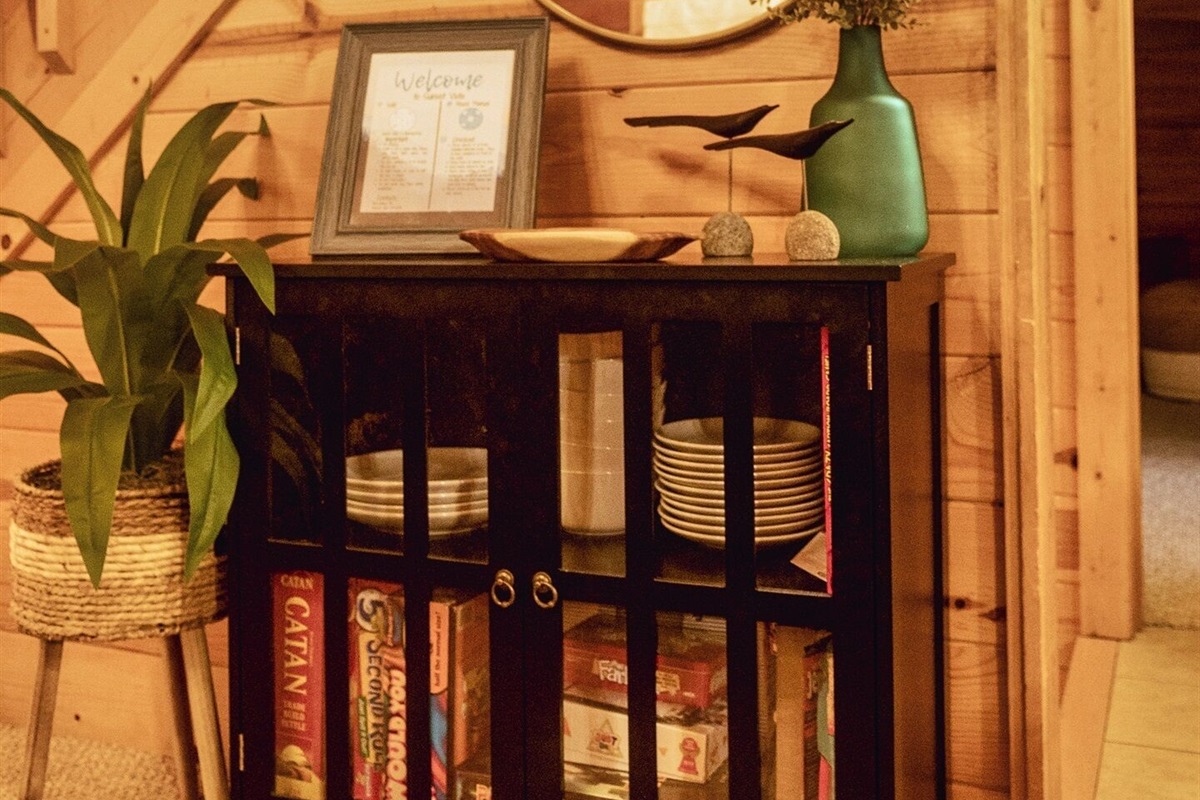 Game cabinet stocked with something for everyone. Catan, Pandemic, Just One, Farkle, Poker set, Ticket to Ride, Bananagrams, Yeti in my Spaghetti, Spot It