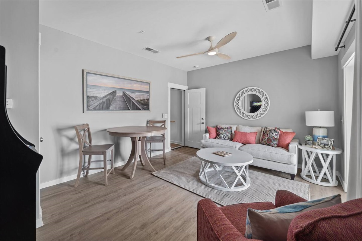 Ground floor living room with couch, arcade, and access to the hot tub