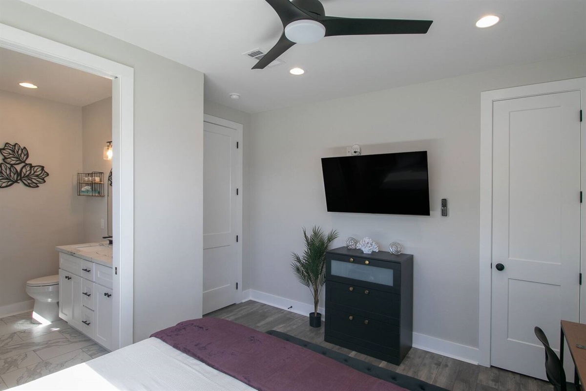 "Ultimate Relaxation: Primary Bedroom with Spa-like Ensuite, Ceiling Fan, and Tranquil Ambiance"