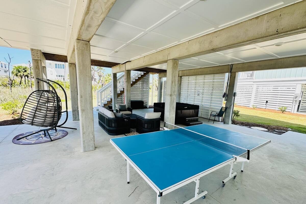 Cozy covered patio with comfortable seating and a ping pong table, perfect for laid-back lounging and friendly competition