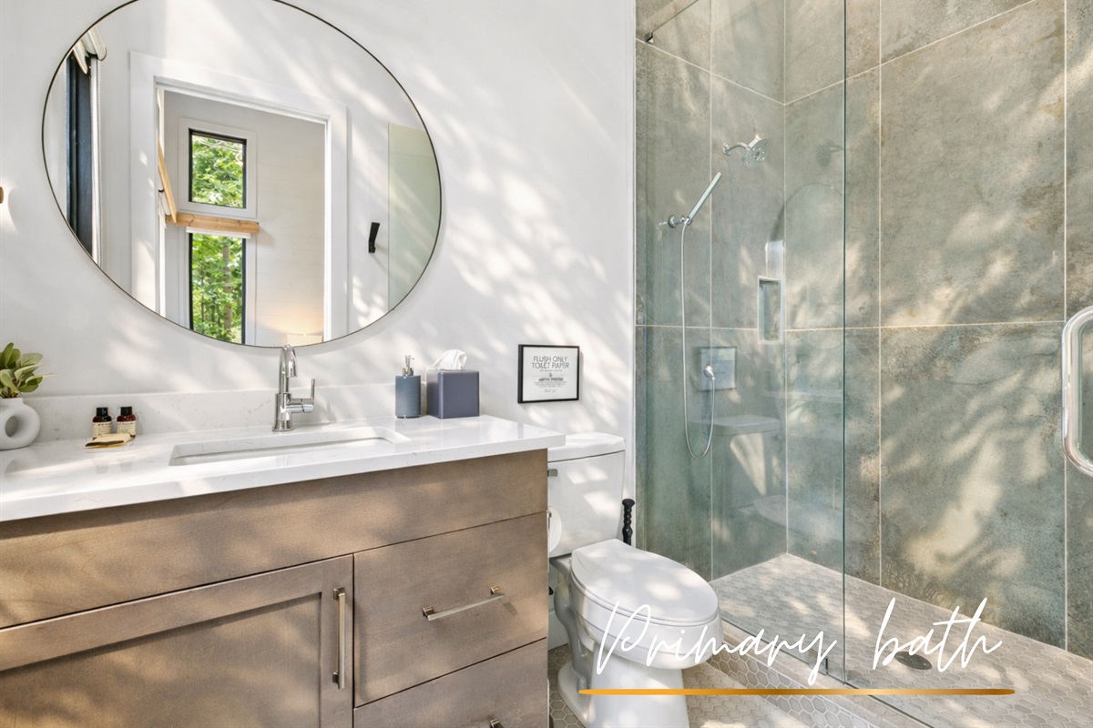 The sleek primary bathroom features a walk-in glass shower and contemporary finishes for a spa-like experience.