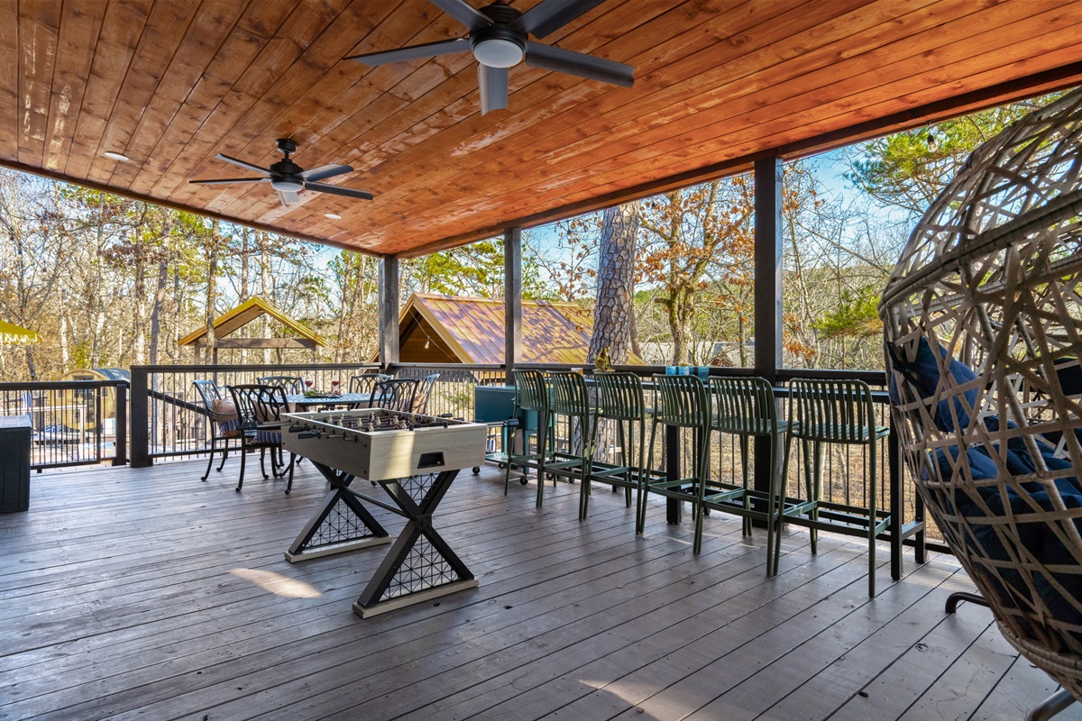 Covered Porch: Unwind with nature views, foosball, and comfy seating for your best outdoor moments!
