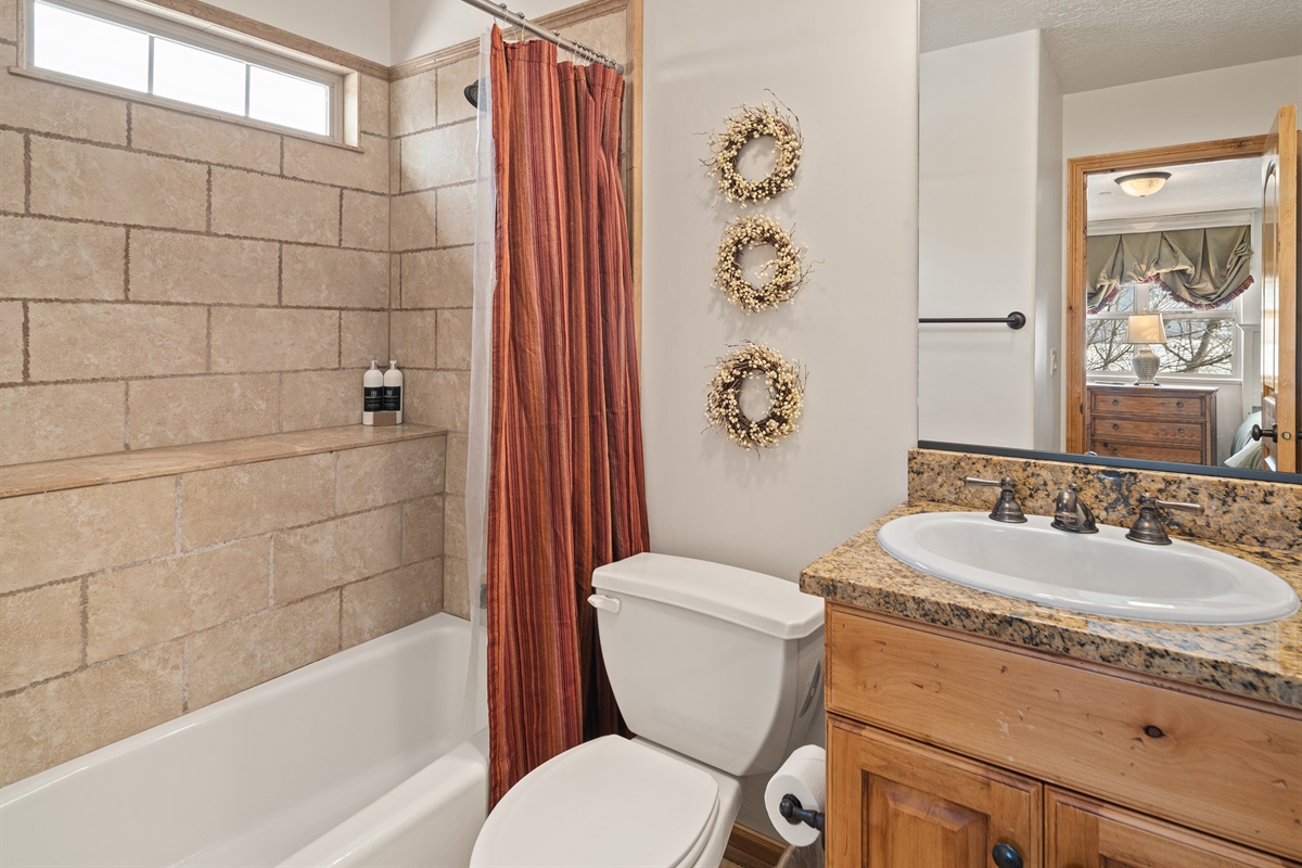 Bathroom with tub/shower combo and rustic finishes