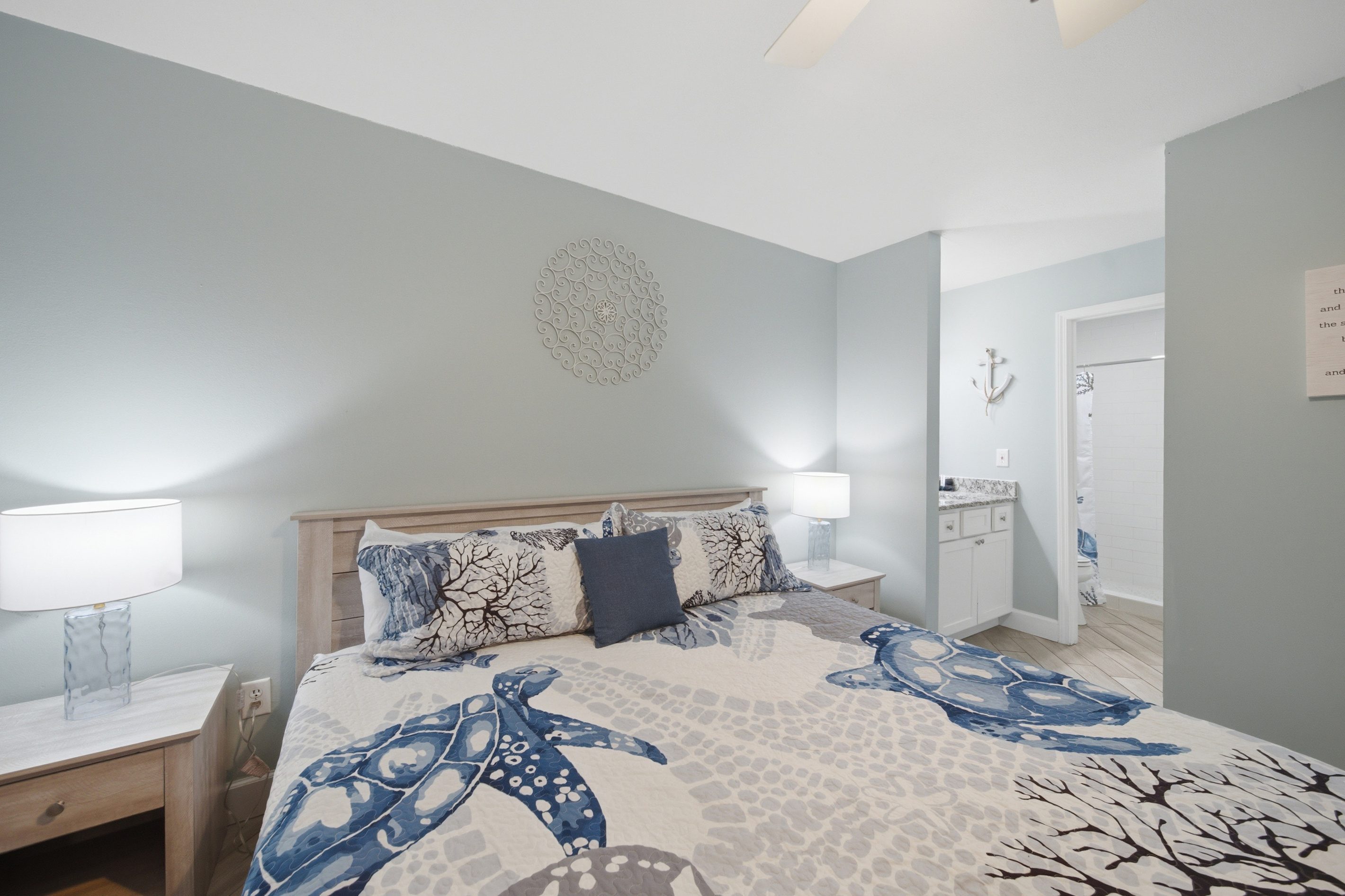 Primary bedroom with playful sea turtle-print bedding and cozy lighting