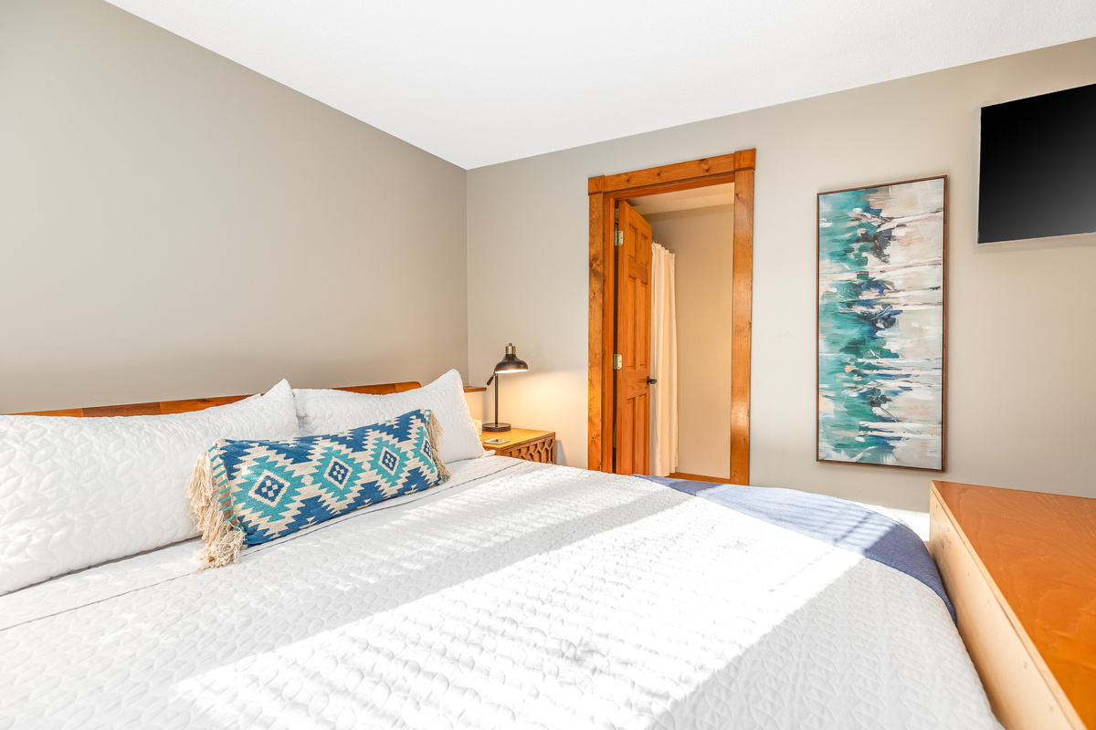 Bedroom 3 featuring a King bed and a Roku Smart TV, and an ensuite bathroom; one of three bedrooms located on the lower level.