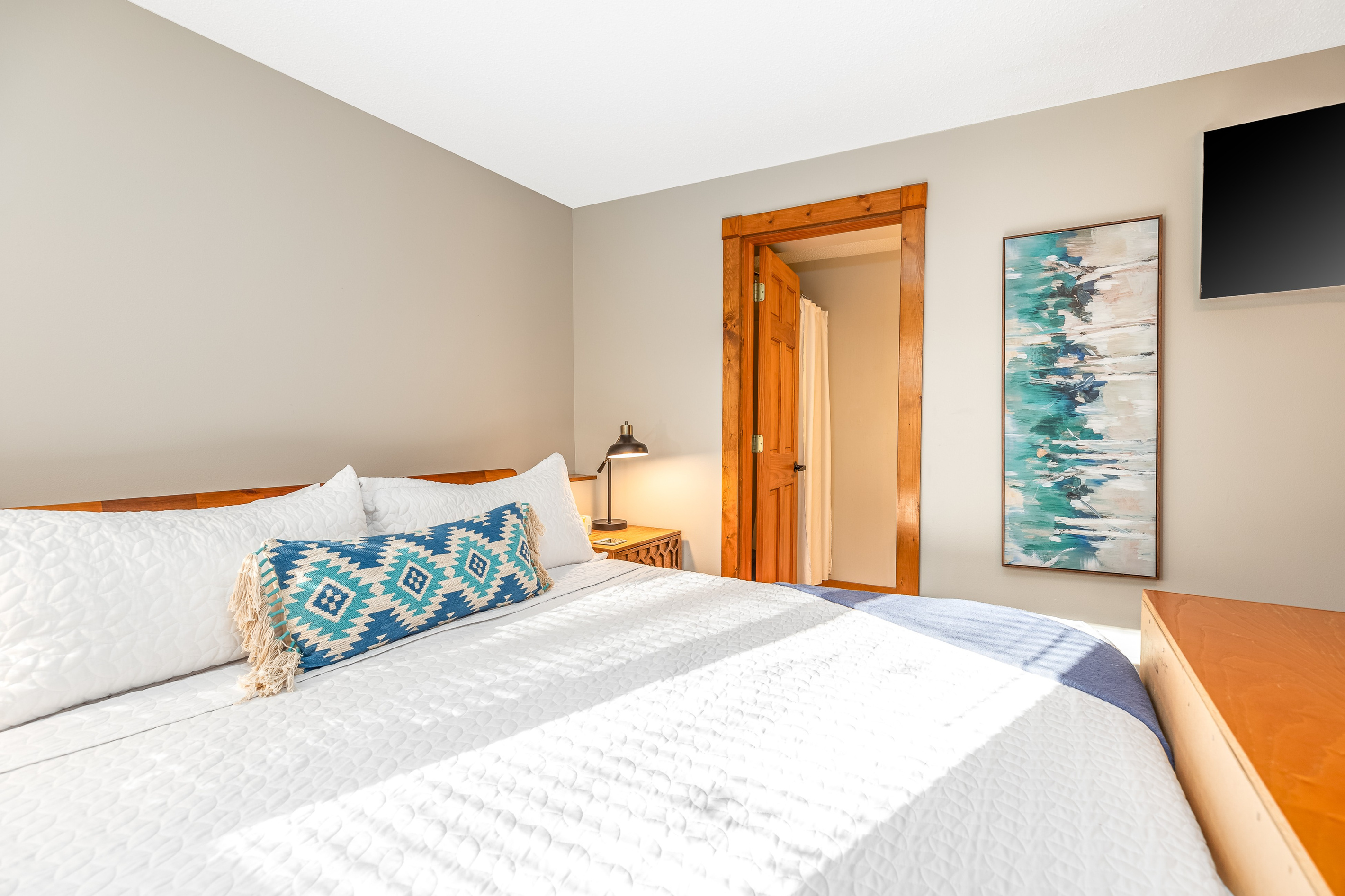 Bedroom 3 featuring a King bed and a Roku Smart TV, and an ensuite bathroom; one of three bedrooms located on the lower level.