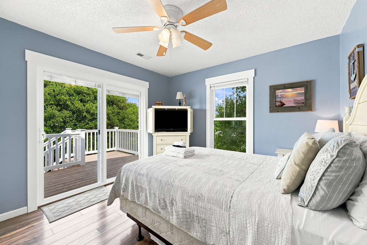 Relax in a spacious queen bedroom featuring a Smart TV and private access to the upper deck