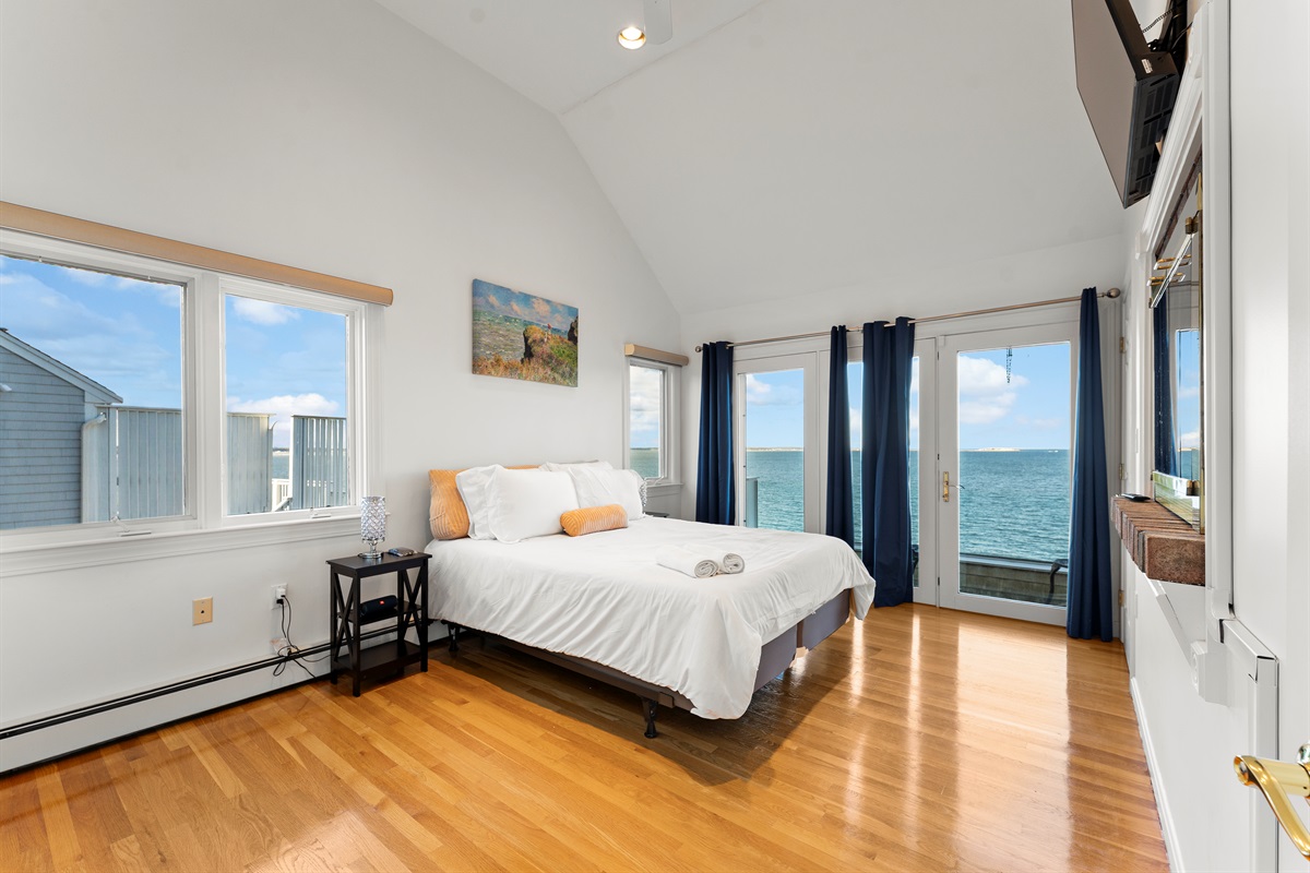 Second-level bedroom featuring a queen bed and serene ocean vistas.