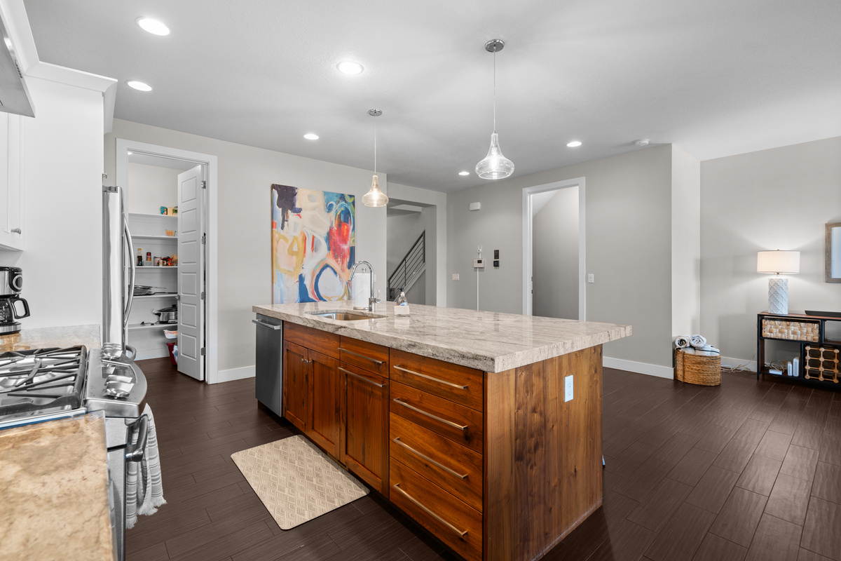 Large kitchen island, gas stove, modern appliances, and ample prep space.