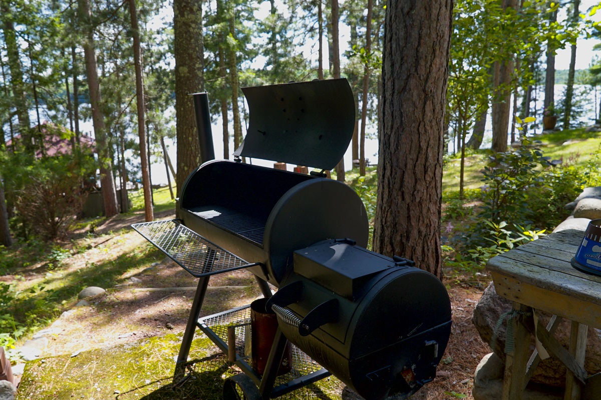 There is a grill on the patio in front of the cottage.