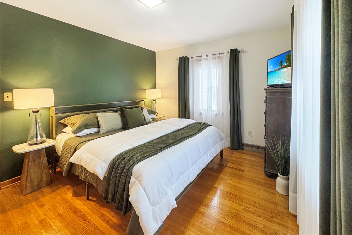 King-size comfort with luxury bedding and elegant velvet drapery.