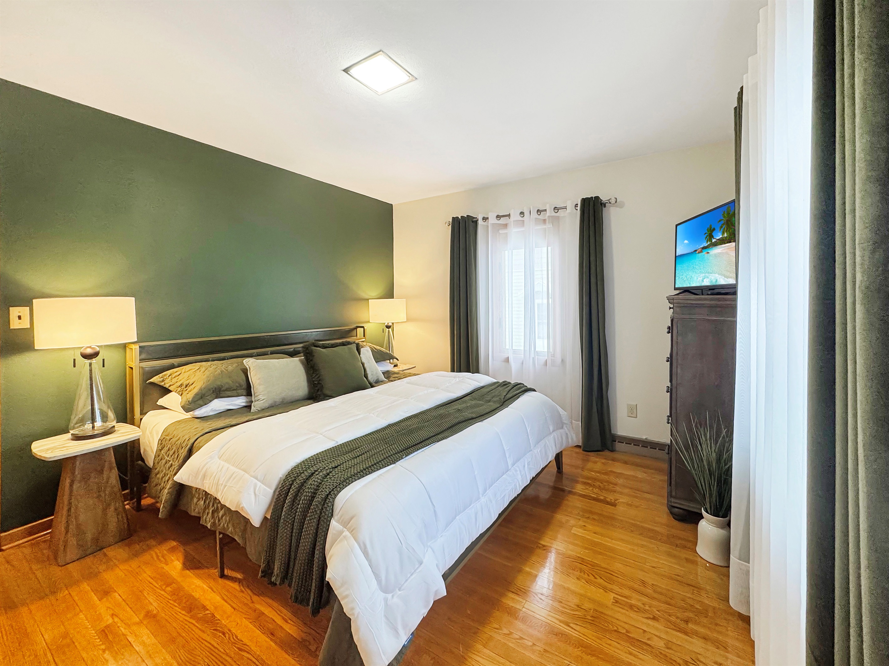 King-size comfort with luxury bedding and elegant velvet drapery.