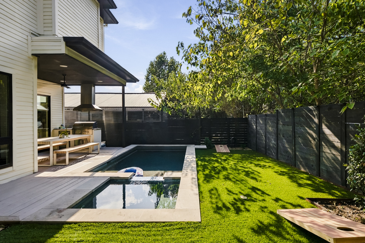 Another angle of the backyard's private pool and green turf space.