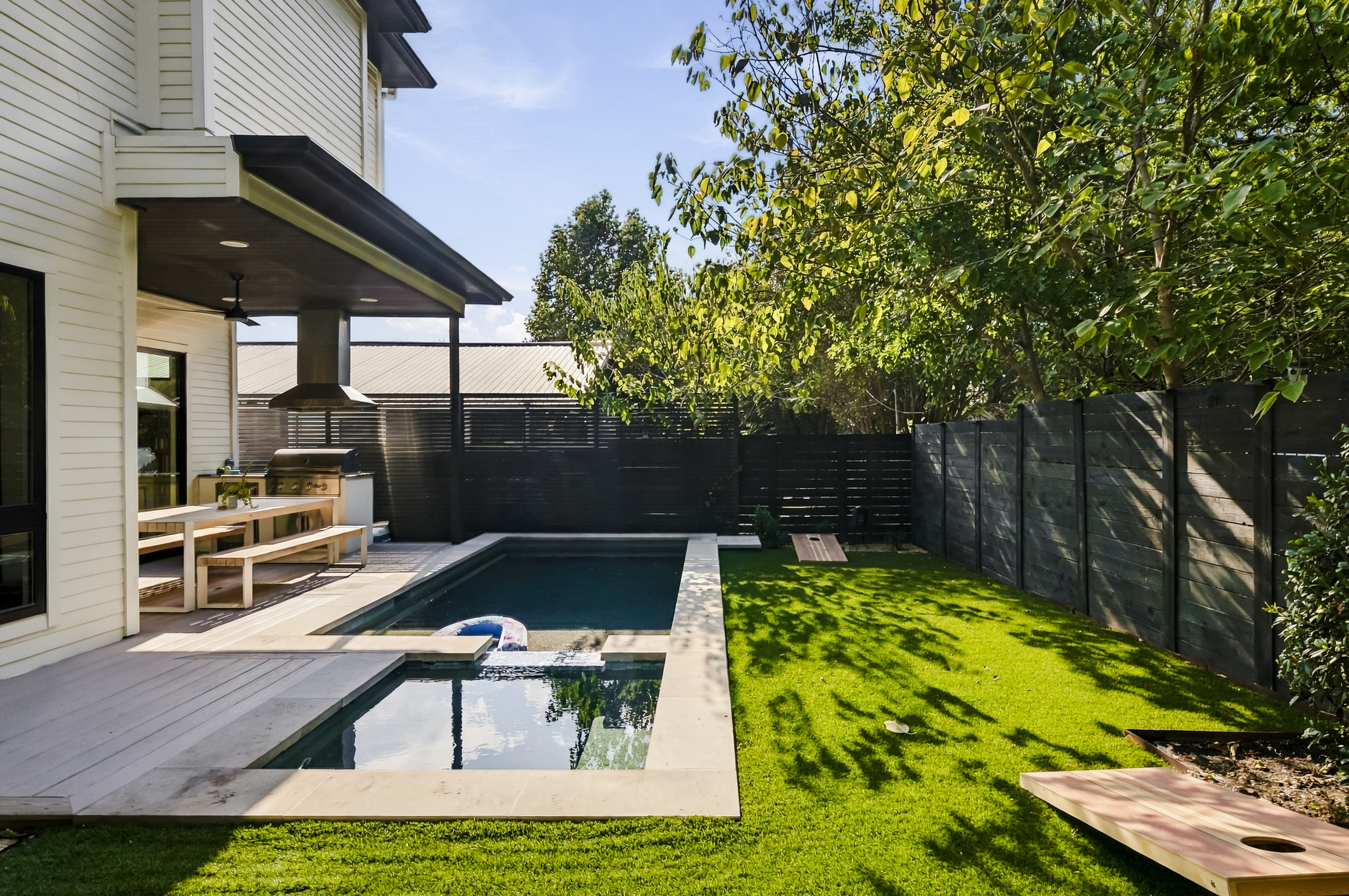 Another angle of the backyard's private pool and green turf space.