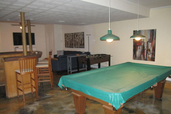 Regulation size pool table and a foosball table as well as a TV and a bar area. This floor also has a full bathroom with shower.