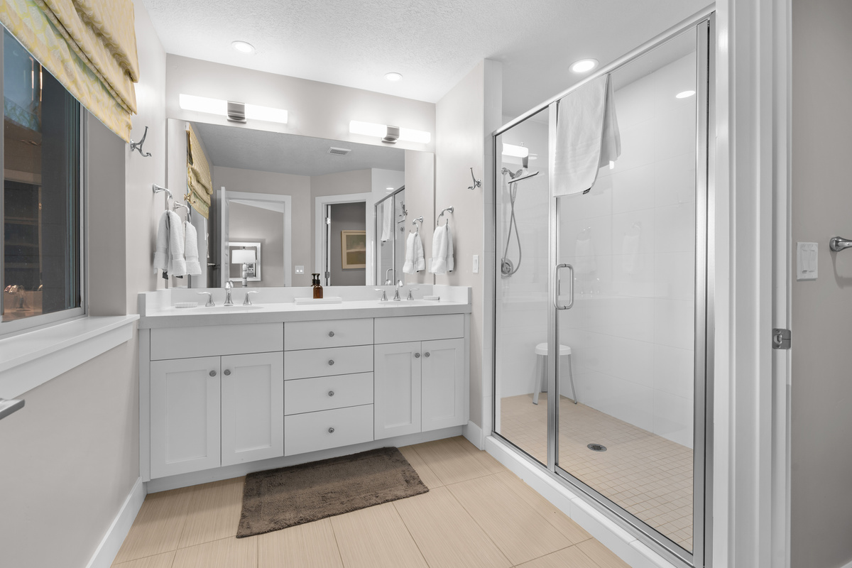 Luxurious primary bathroom with bidet. double vanity, and a walk-in shower.