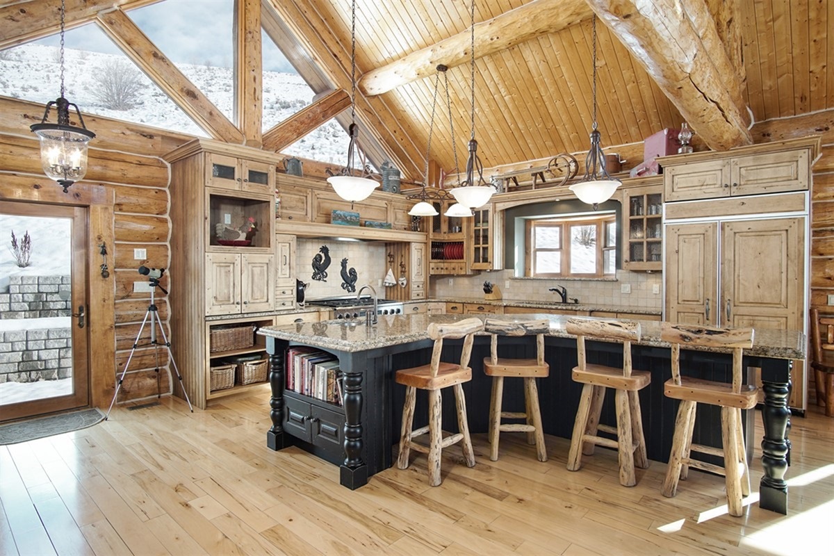 Fully stocked gourmet kitchen with bar seating and rustic finishes