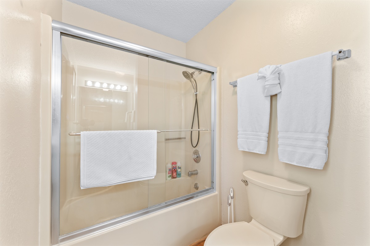 Tub/shower combo with glass doors—fresh towels provided for every stay.