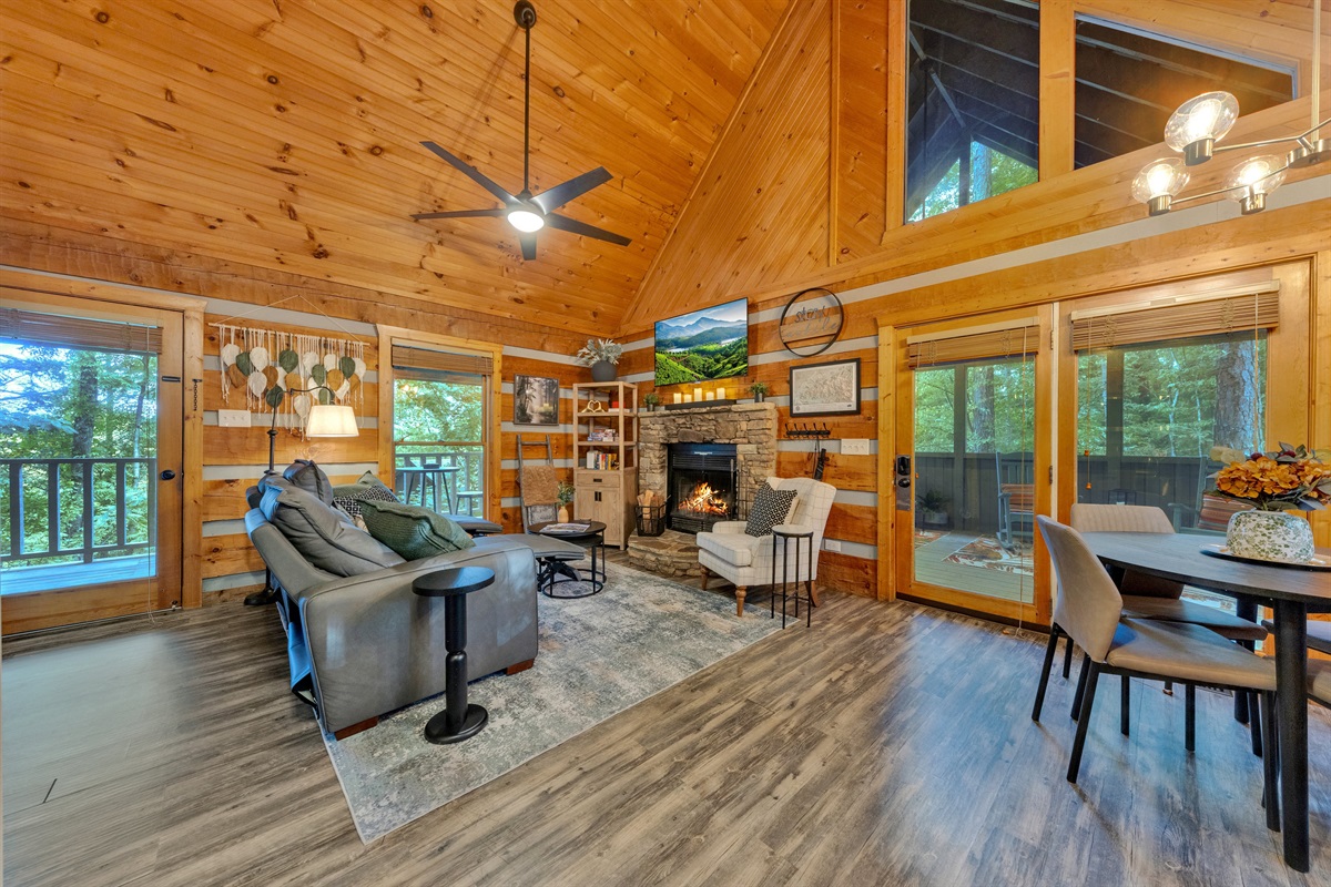 Vaulted wood ceilings, a cozy stone fireplace, and a wall of windows create the perfect mountain retreat