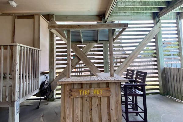 Poolside tiki hut with seating and charm.
