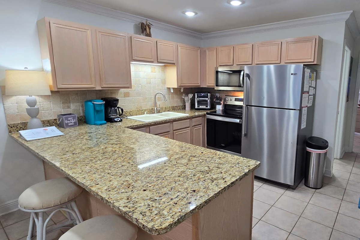 Granite countertops, full stainless appliances, and enough prep space to cook something worth sitting down for &mdash; this kitchen earns its keep.
