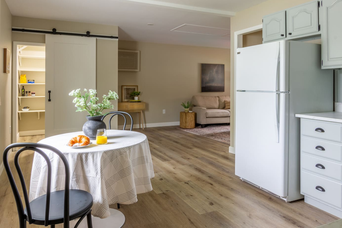An open flow from the dining nook to the living room, with a barn door pantry for extra storage.