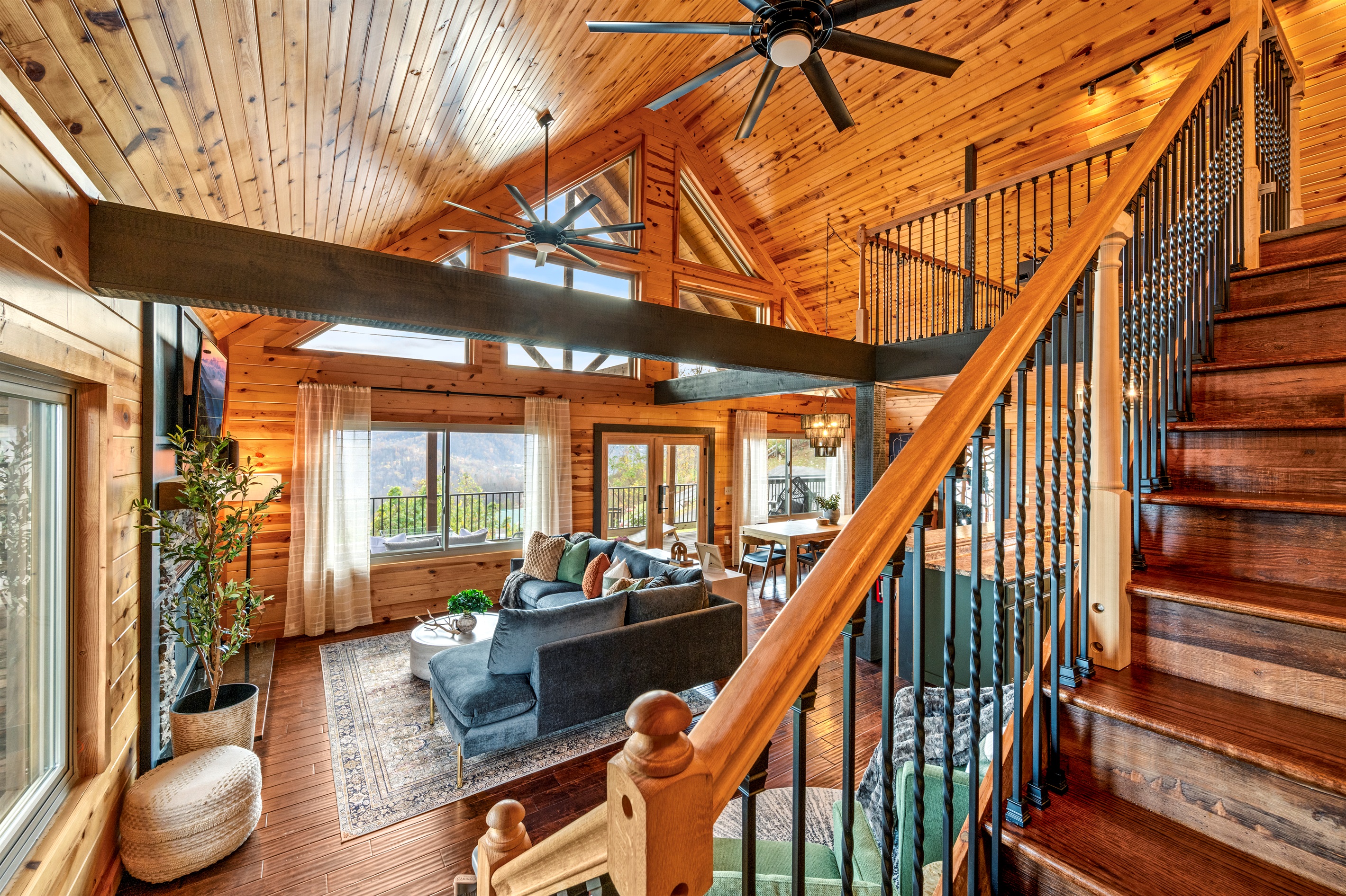You'll love the expansive open-concept design at Signature Stay, featuring large windows, soaring vaulted ceilings, and oversized fans.