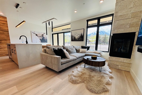 Open floor plan living room with gas fireplace and 53” OLED smart TV